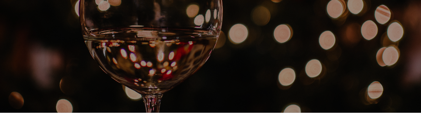 Glass of white wine with a dark background and abstract lights