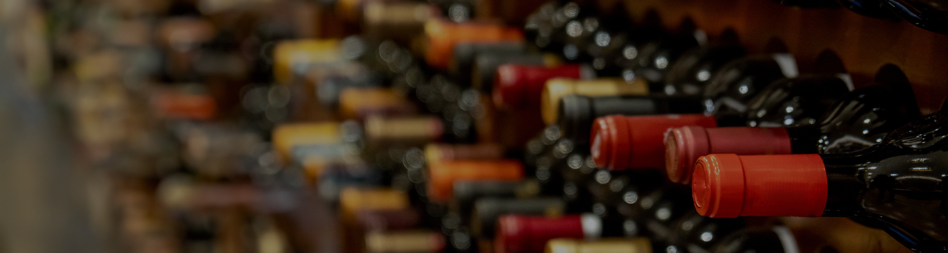 Wine bottles in a shelf at diagonal to view the bottle tops