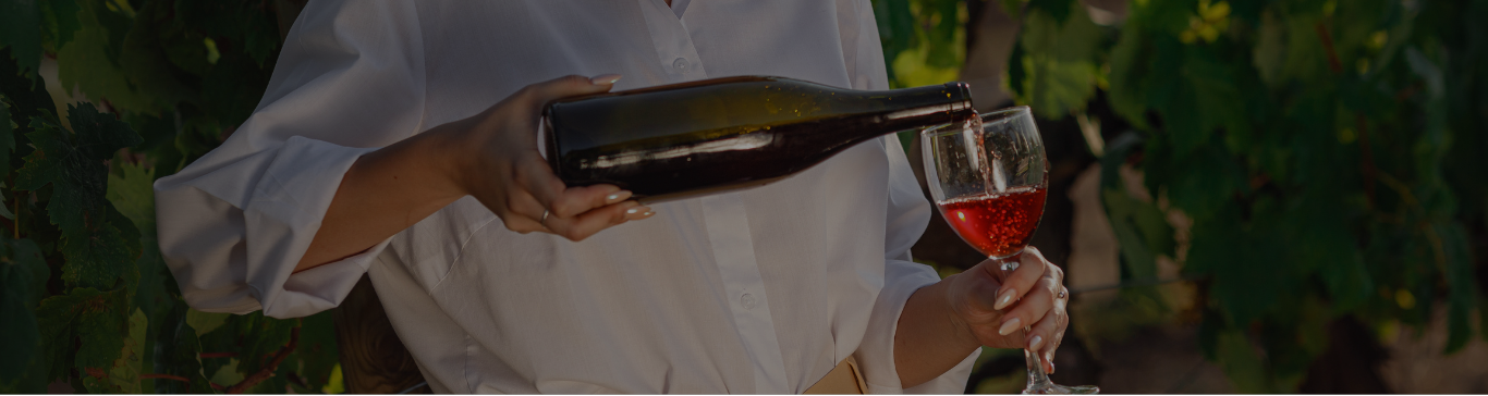 Woman pouring wine in a vineyard
